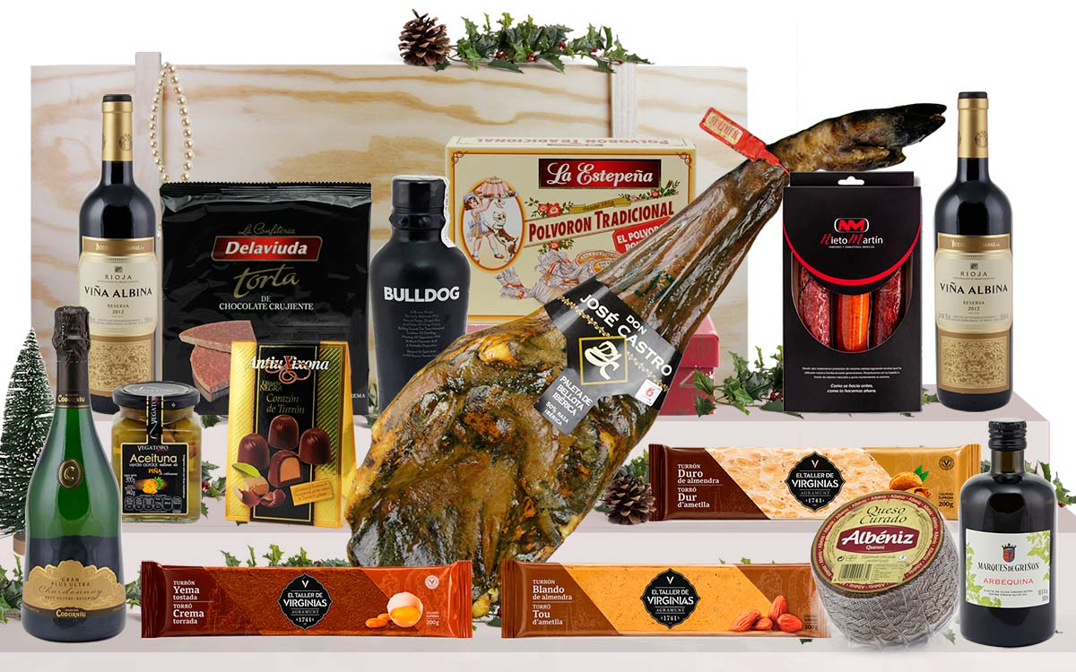 Lot gourmet amb paleta ibèrica de gla de Salamanca, cava, vi de Rioja, ginebra premium, oli d’oliva verge extra, ibèrics, formatge, torrons i dolços, presentat en una caixa jamonera de fusta.