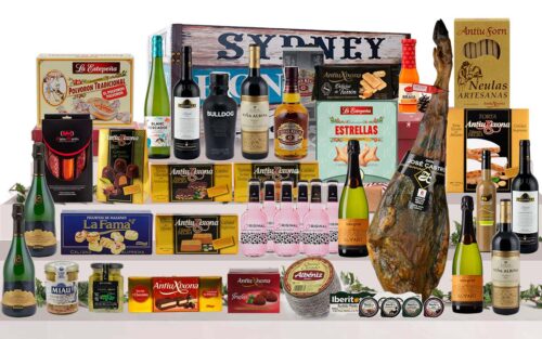 Baúl gourmet amb pernil ibèric de gla de Salamanca, Corpinnat, caves, vins de Rioja, vi blanc, licors, whisky, ginebra, tòniques, ibèrics, formatge, torrons, bombons i dolços, presentat en un baúl de fusta pintat.