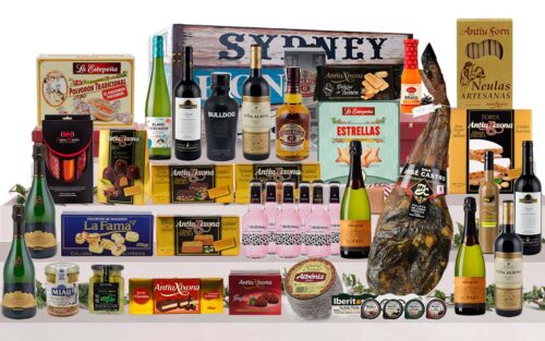 Bagul gourmet amb paleta ibèrica de Salamanca, Corpinnat, caves, vins de Rioja, vi blanc, licors, whisky, ginebra, tòniques, ibèrics, formatge, torrons, bombons i dolços, presentat en un bagul de fusta pintat.