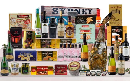 Bagul gourmet amb paleta ibèrica de gla de Salamanca, Corpinnat, caves, vins de Rioja, vi blanc, licors, whisky, ginebra, tòniques, ibèrics, formatge, torrons, bombons i dolços, presentat en un bagul de fusta pintat.